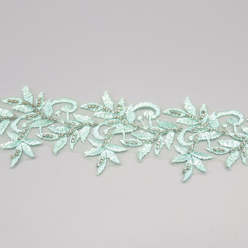 Light green embroidered lace featuring beaded leaf motifs