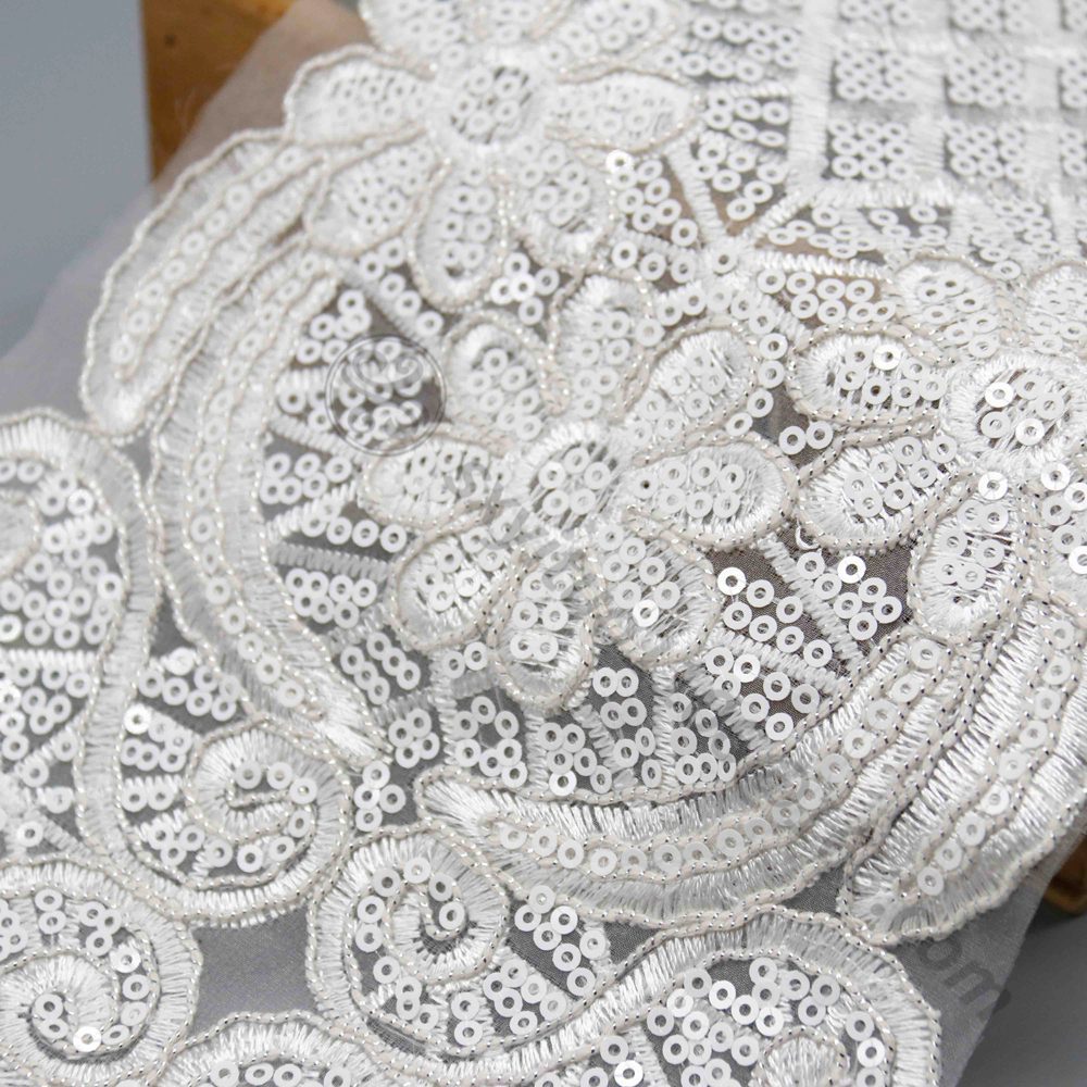 Elegant handcrafted lace trim in white, adorned with sequins and beads