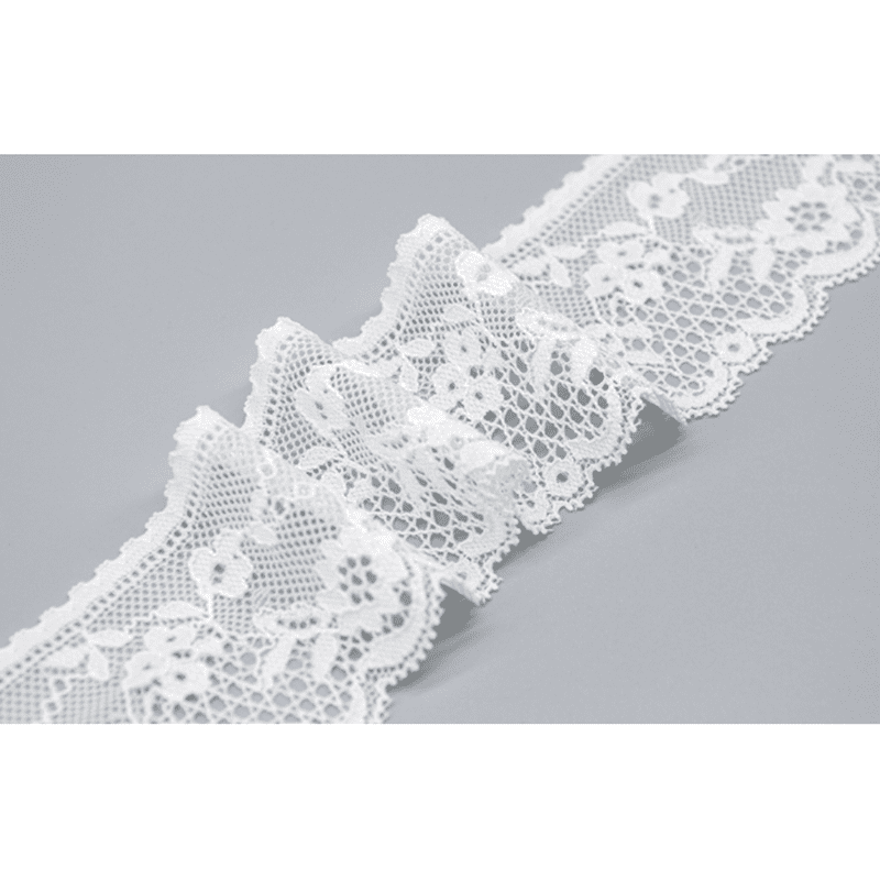 Vibrant image of trending white lace trim featuring a delicate mesh structure, multi-layered floral and vine motifs, and graceful wave edges secured by expert lockstitching; lightweight and high-end, enhancing the sophistication of wedding attire.