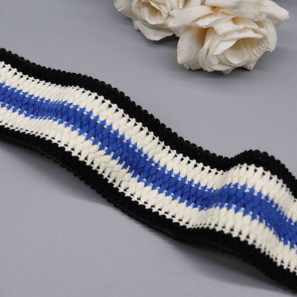 Vibrant image of 4.5 cm wide color-blocked poly cotton webbing showcasing distinct black, white, and blue sections with a textured blue-white interweave and subtle black lace borders; thick and eye-catching, great for garment details, bag straps, and personalized DIY crafts.