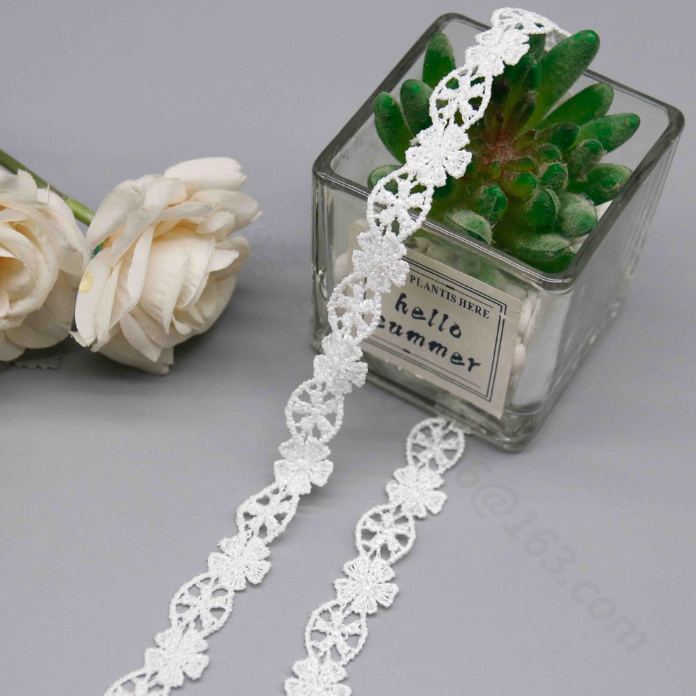 Sophisticated display of a small-scale water-soluble lace trim in clean white, composed of interwoven 3D six-petal blooms with dense, shimmering needlework and traditional eyelet wheel-like motifs for transparency; backing-free design yields soft wave borders and light rigidity, enhancing children's or wedding dresses with pure, intricate details on sleeves and skirts.