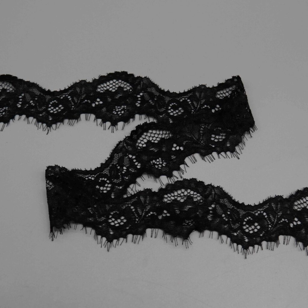 Sophisticated display of two French-style lace trims in black and white, showcasing refined floral patterns on a tulle-like mesh base with fine eyelash edges, using a comfortable, flexible 90% nylon and 10% spandex blend; designed for luxurious ladies' apparel.