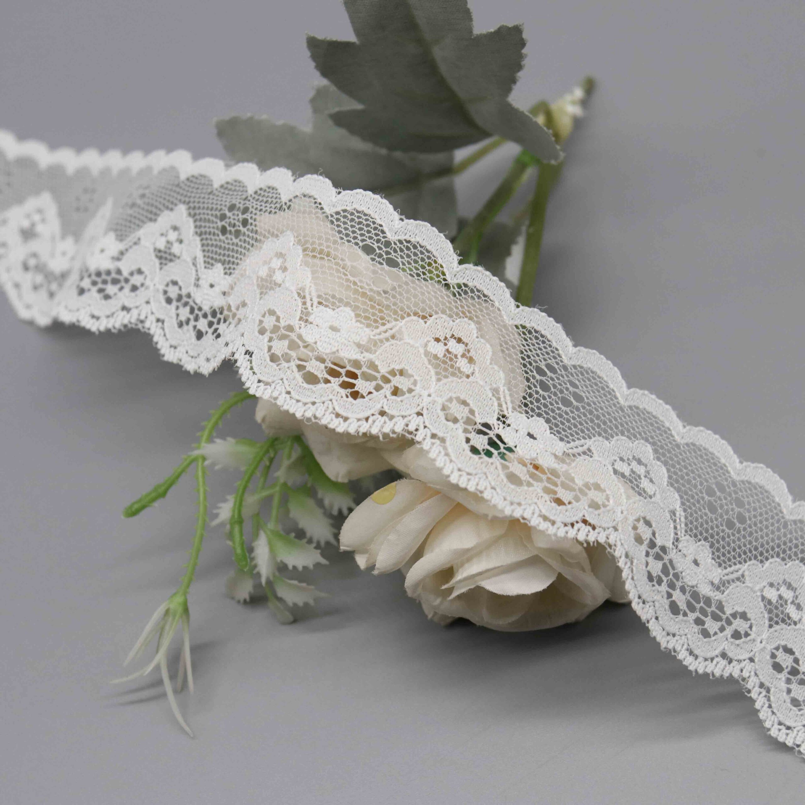 Detailed view of lightweight pure white scalloped lace trim ribbon on soft nylon mesh, showcasing a practical straight sewing edge and undulating scalloped borders with vivid embroidered floral patterns for layered contrast; simple yet sophisticated, suited for dress waistlines, sleeves, and bridal details.