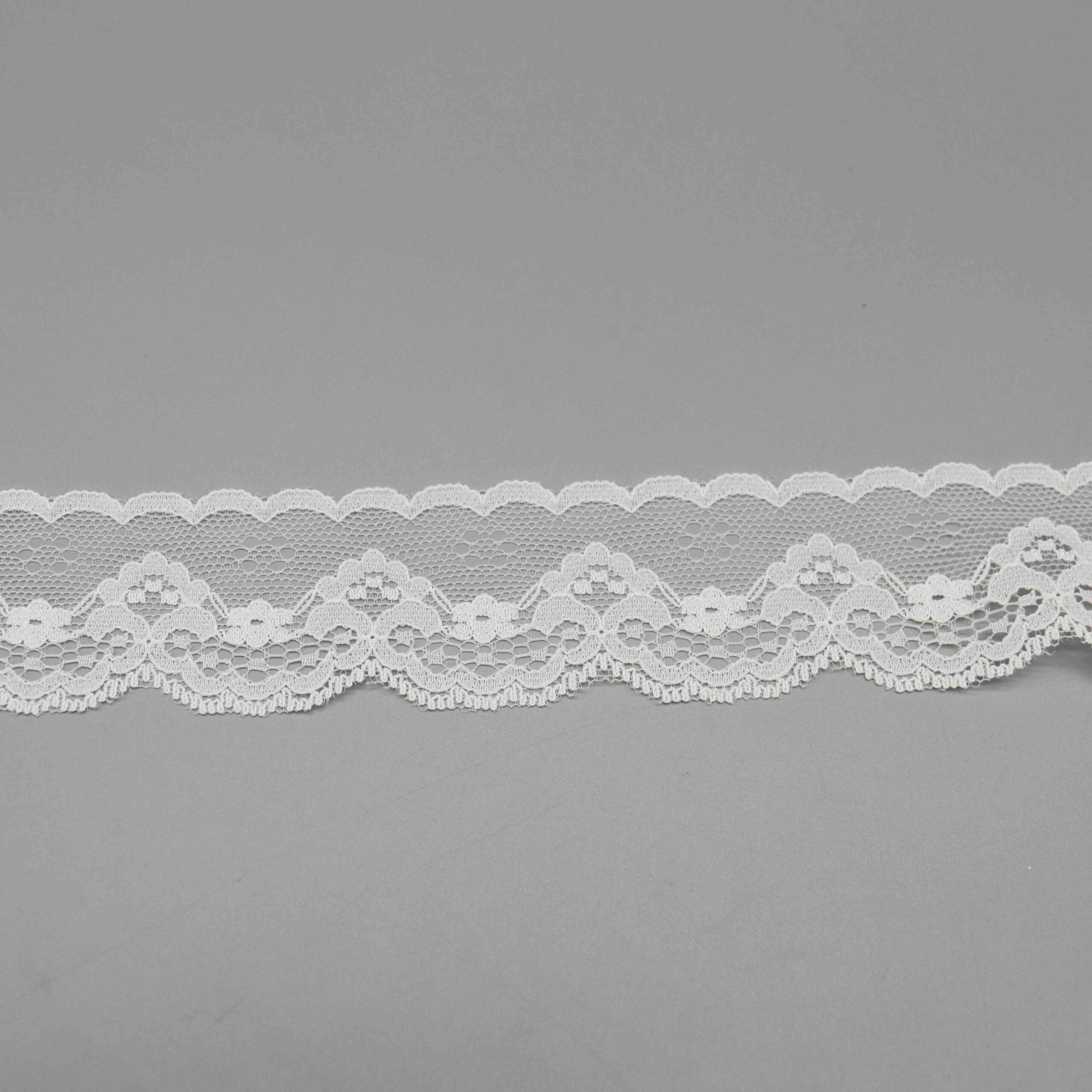 Vibrant image of delicate pure white scalloped floral lace ribbon on translucent nylon mesh, with a straight side for seamless sewing and elegant scalloped arcs featuring intricate white flower embroidery against the open base; refined and versatile for bridal hems, dress sleeves, and accessory details.