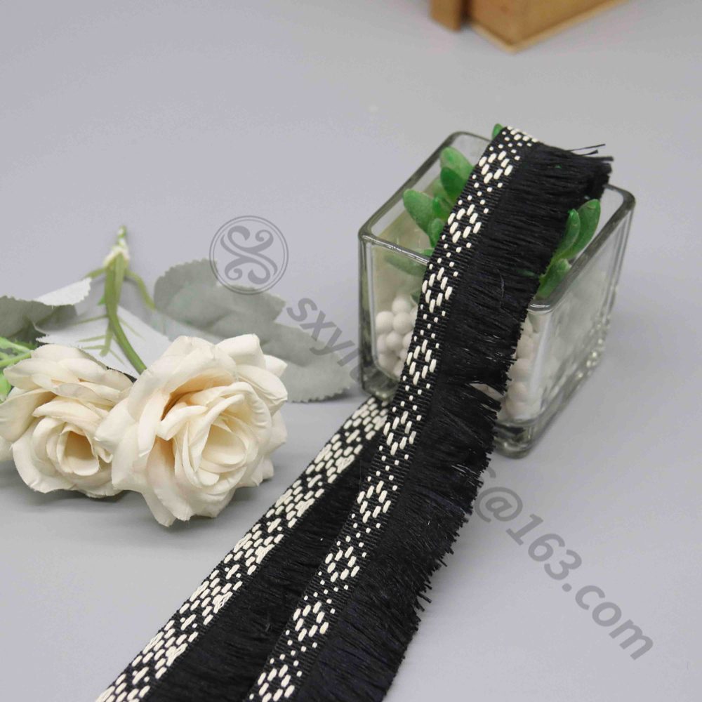 Macro close-up of the intricate diamond lattice woven pattern on the black and white polyester trim header.