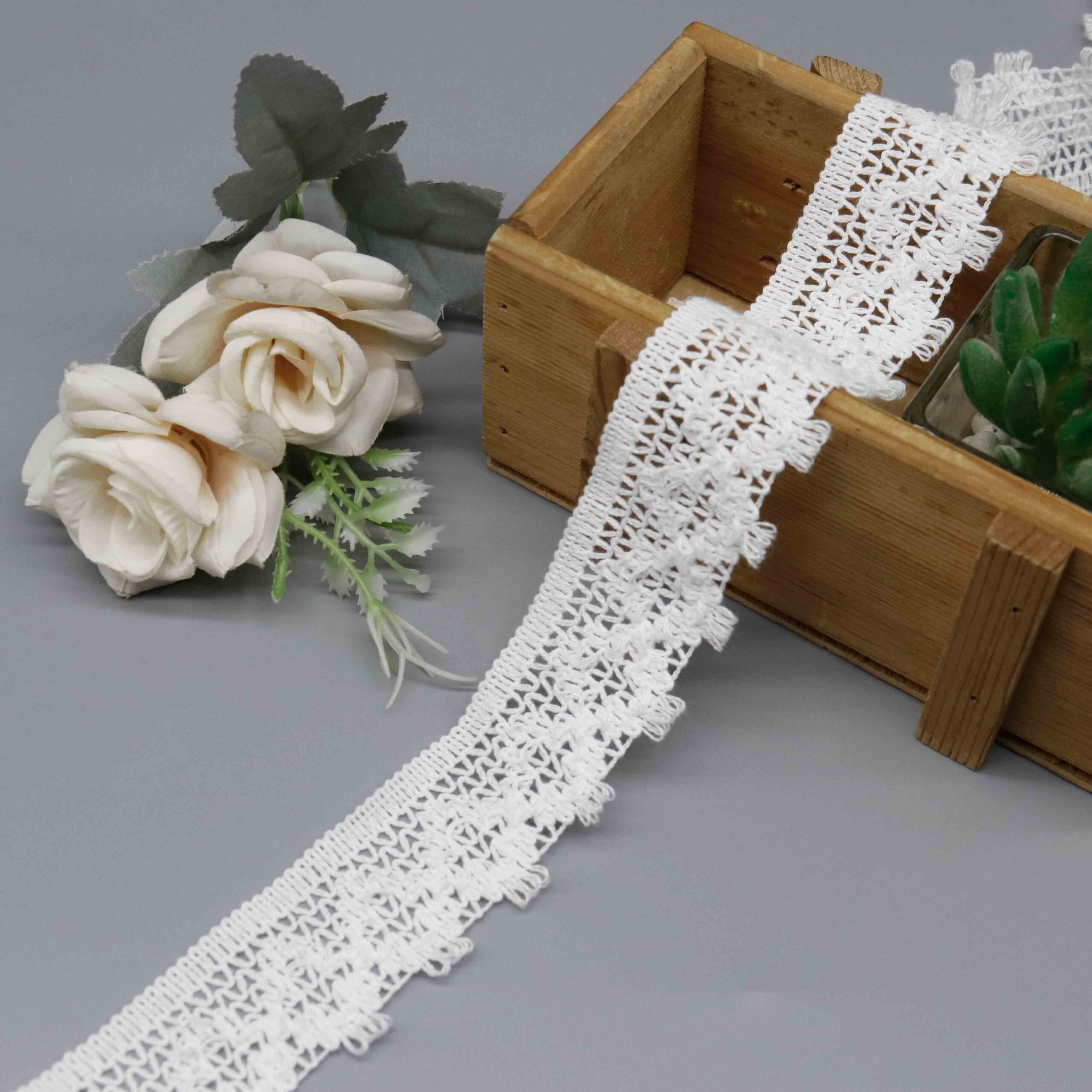 Front-facing shot showing the triangular mesh openwork and loop fringe border clearly.