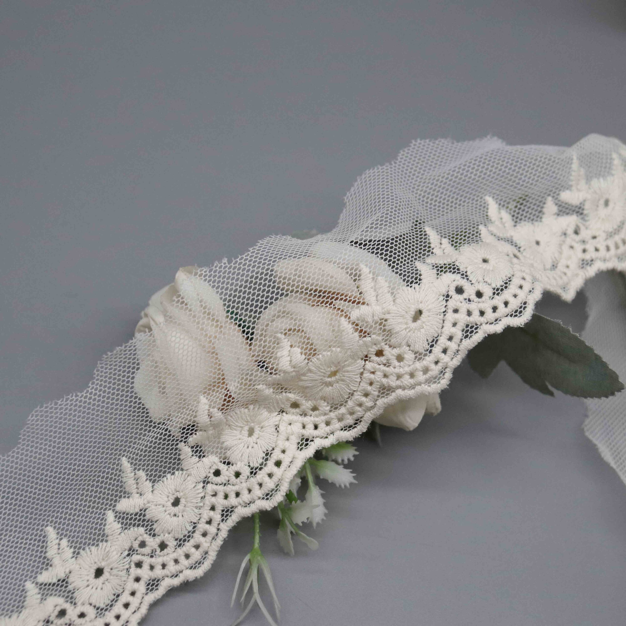 Angled shot capturing the raised satin-stitch embroidery dimension against the transparent mesh base.