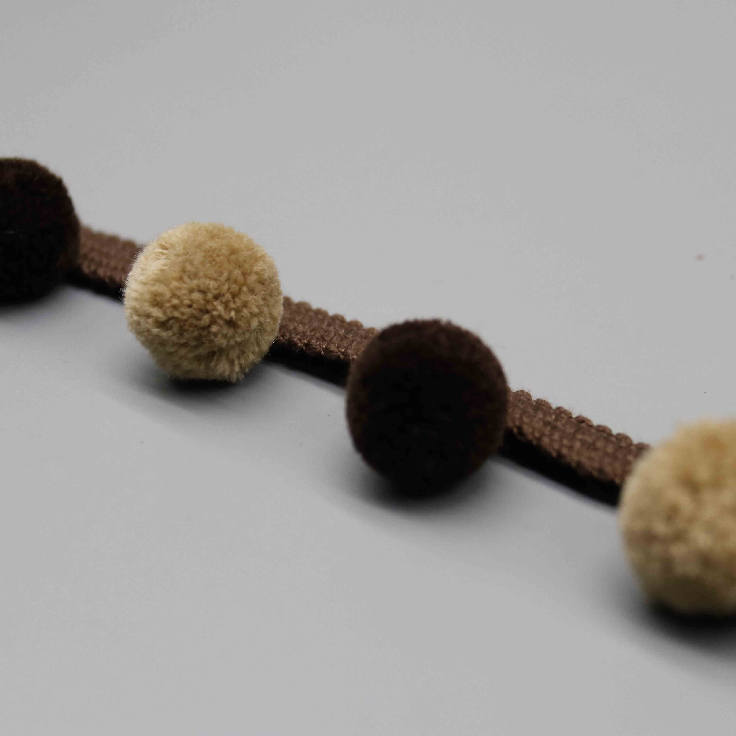 High-resolution detail showing the stretchy braided elastic header construction in brown.