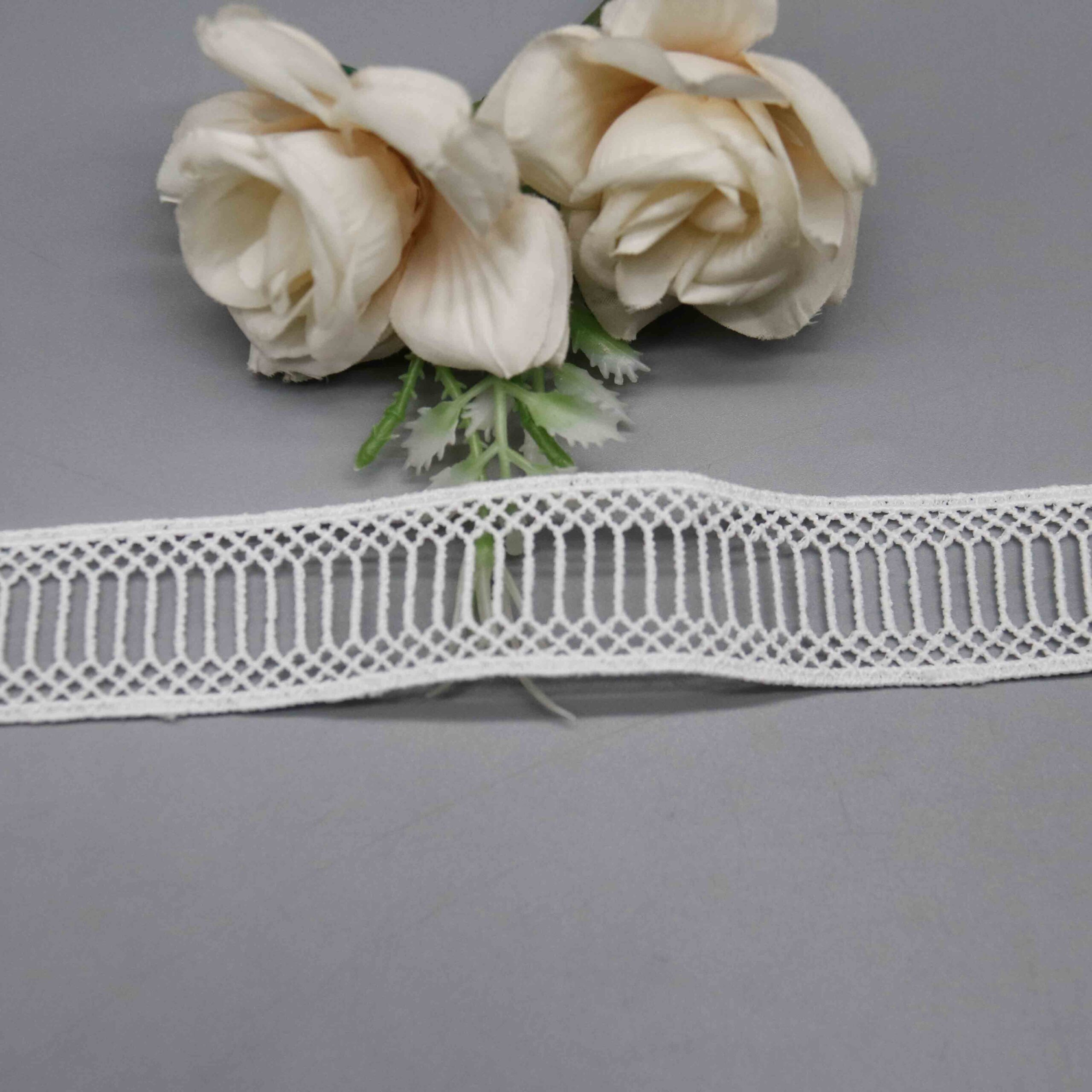 Macro close-up capturing the fabric's openwork grid and fine thread precision.