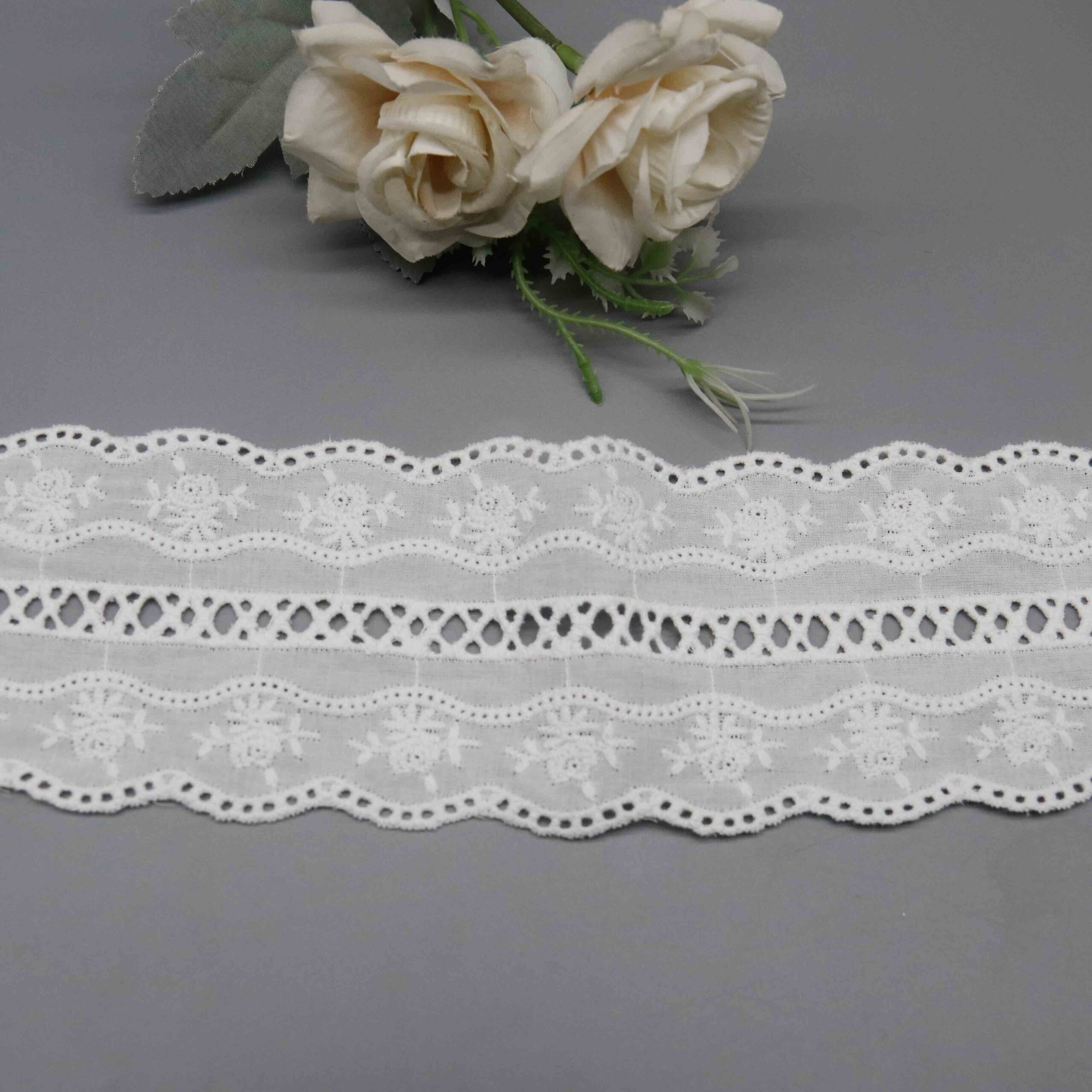 High-resolution focus on eyelet-bordered wave edge construction and feminine hemline quality.