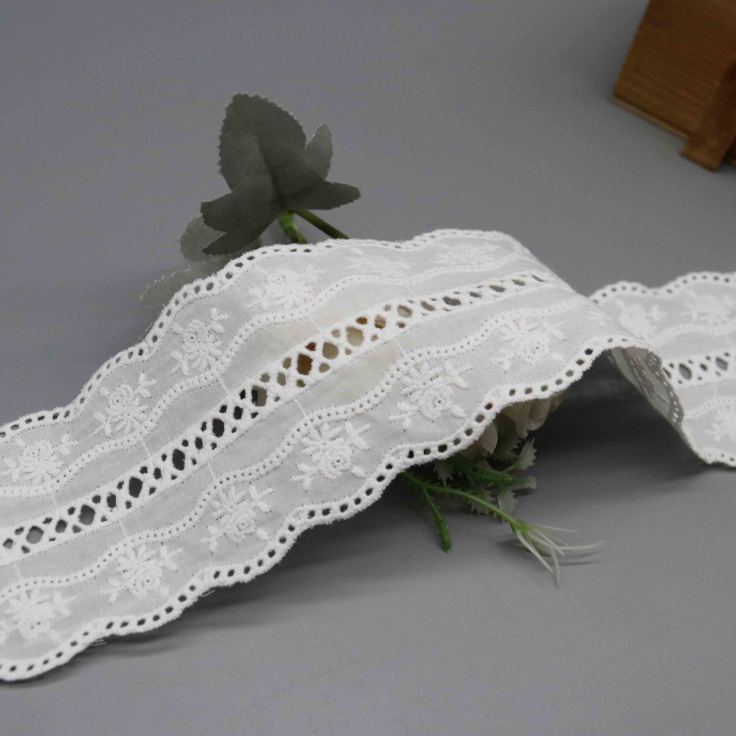 Backlit demonstration of punched cutwork density and breathable see-through characteristics through fabric.