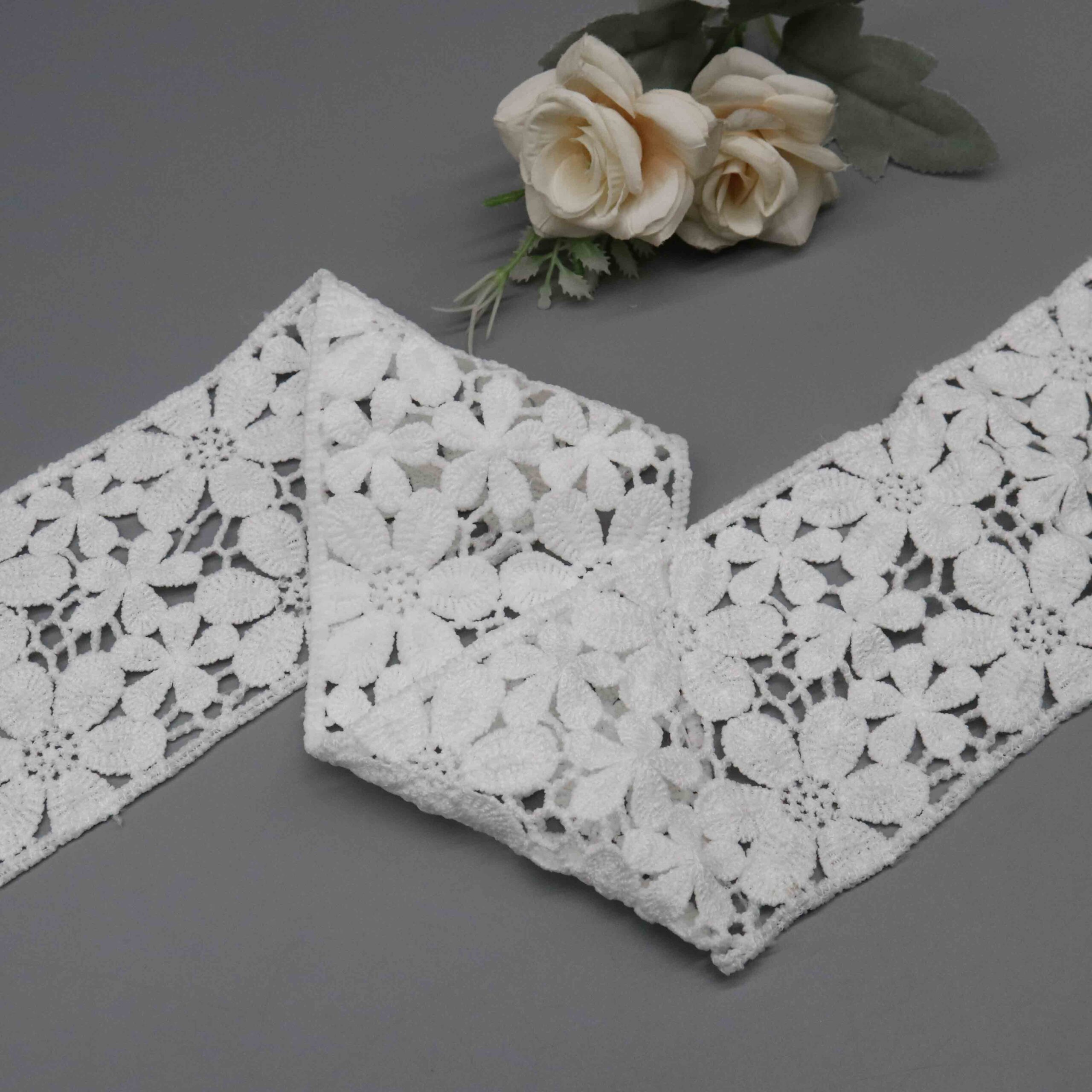 Backlit demonstration of dense embroidery relief and delicate see-through characteristics through fabric netting.