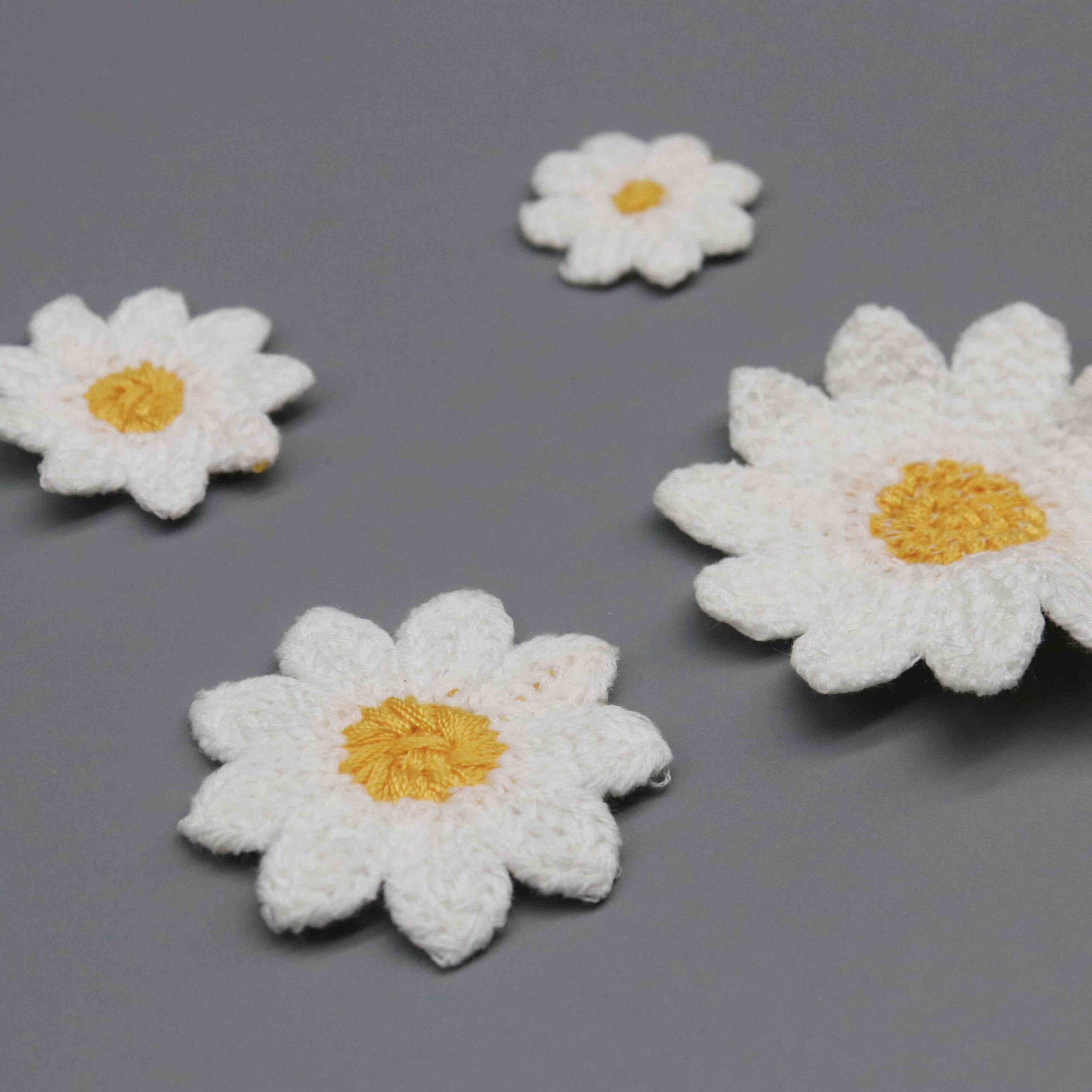 Macro close-up capturing textured satin-stitch center and raised petal thread craftsmanship.