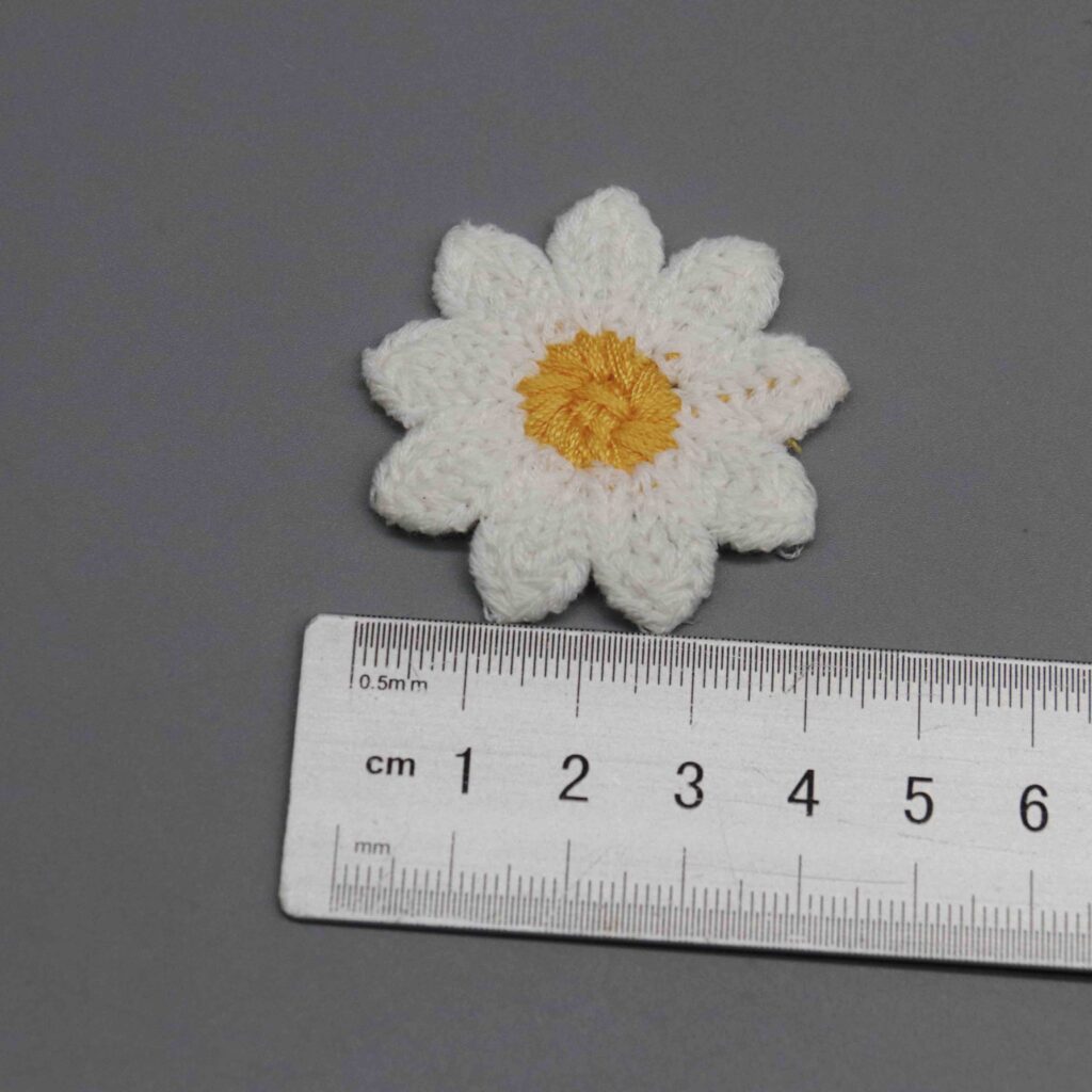 Sizing gauge displaying exact 2.3cm dimension of small decorative flower patch
