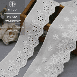 Two widths (4.8cm and 6.6cm) of YI TUO's white floral cotton eyelet lace, displayed on a wooden surface
