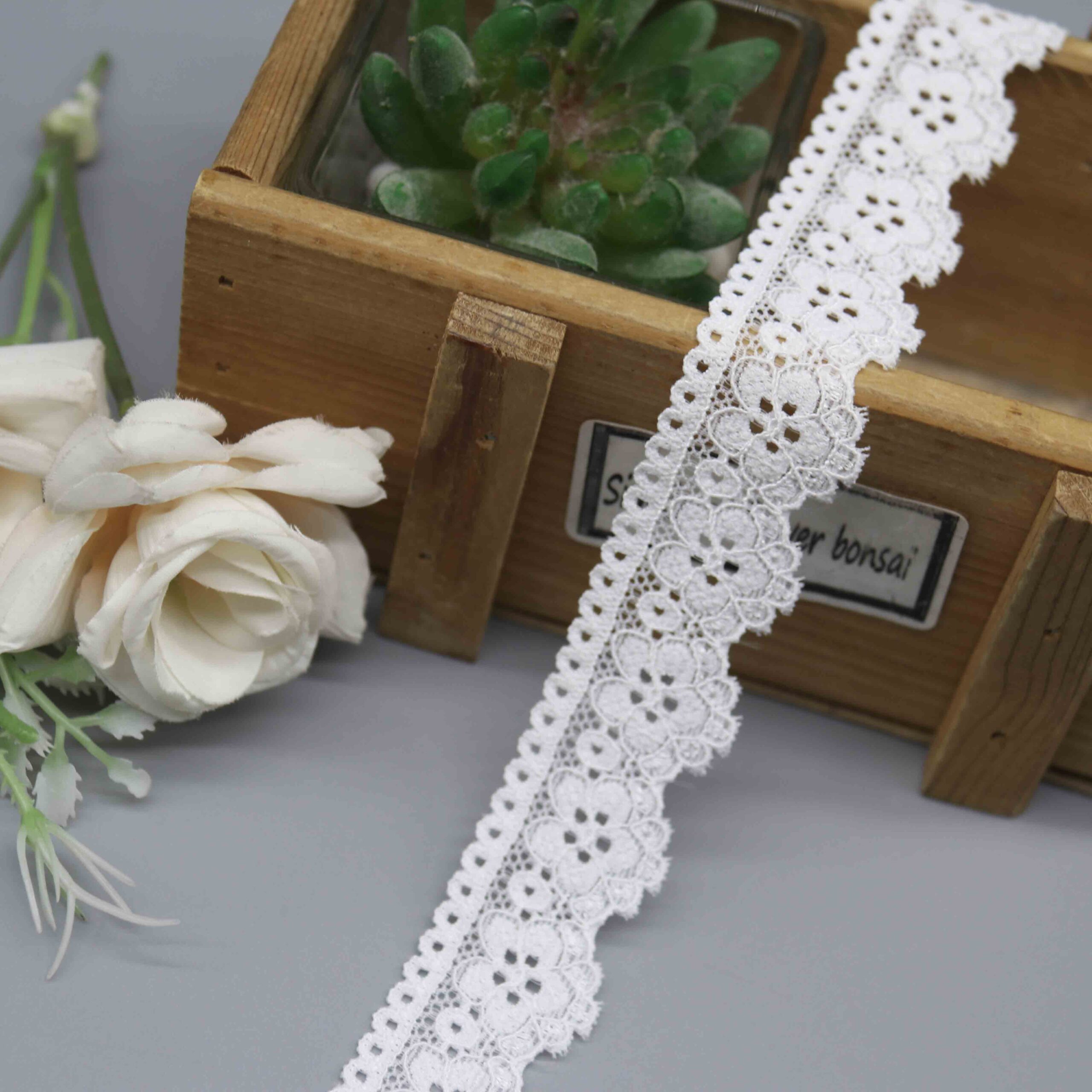 a 2.6cm white galloon stretch lace with a symmetrical floral pattern for lingerie bands.