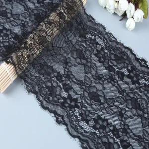 Detailed black floral lace trim ideal for dressmaking, sewing projects, and decorative crafts, showcasing delicate and soft fabric texture.
