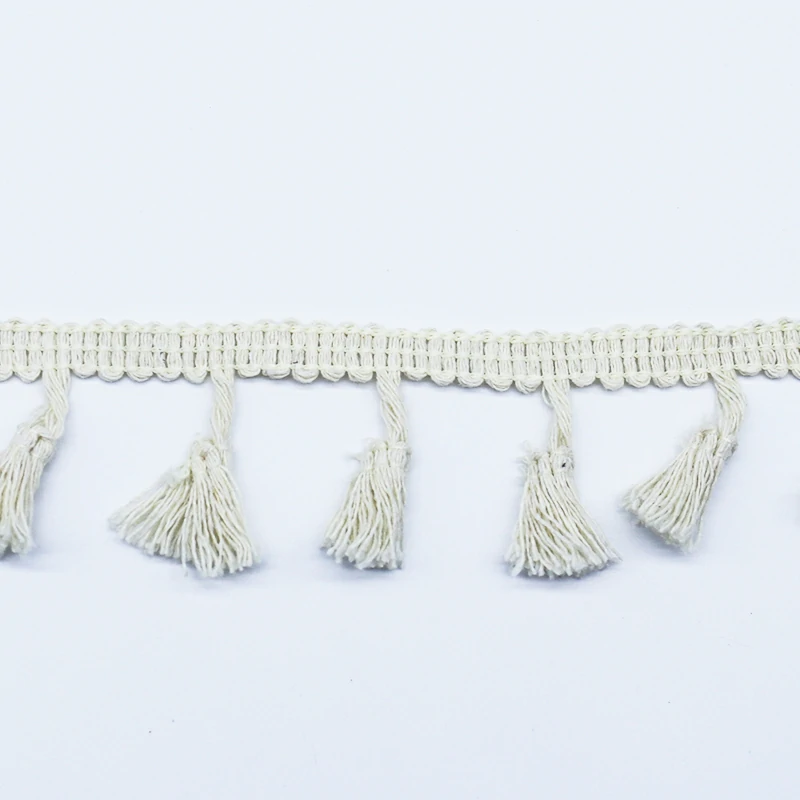 Individual broom tassel close-up showing twisted neck tie and loose strand ends.